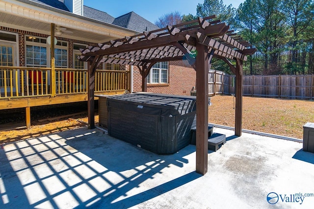 view of patio / terrace with a hot tub, a fenced backyard, a ceiling fan, and a pergola