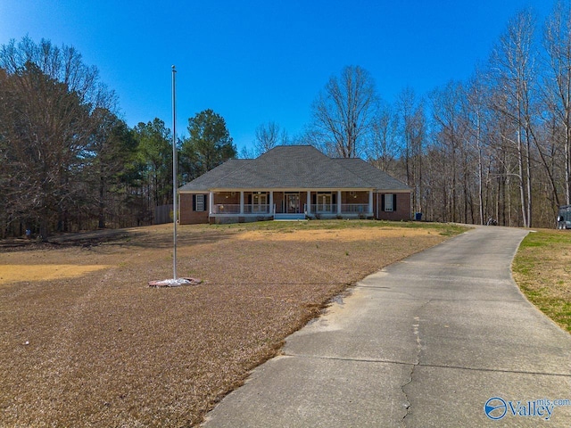 ranch-style house featuring a porch and a front yard