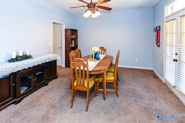 dining space featuring a ceiling fan, light carpet, a textured ceiling, and baseboards