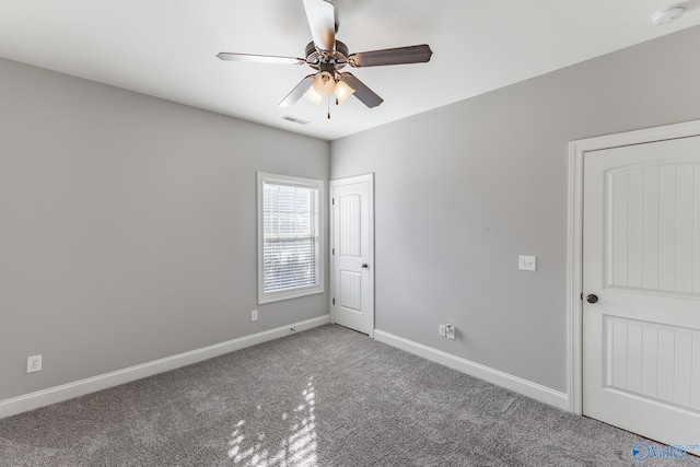 carpeted spare room featuring ceiling fan