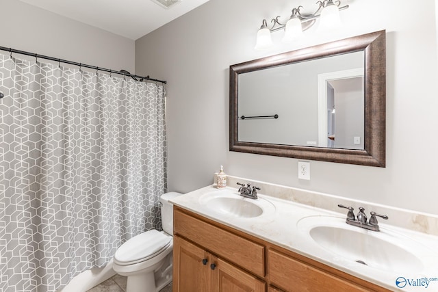 bathroom featuring tile patterned floors, vanity, toilet, and walk in shower