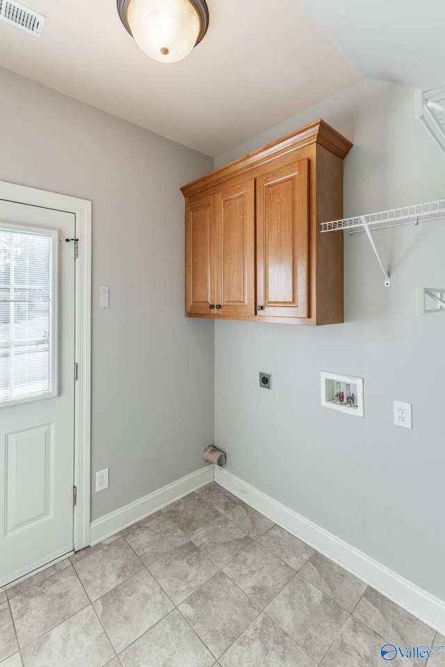 washroom featuring hookup for an electric dryer, washer hookup, light tile patterned floors, and cabinets