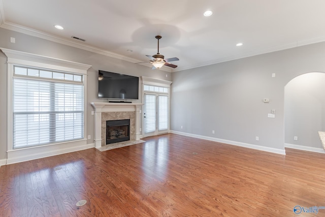 unfurnished living room with light wood-type flooring, crown molding, and a wealth of natural light