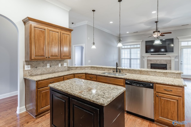 kitchen with sink, stainless steel dishwasher, ceiling fan, a kitchen island, and light hardwood / wood-style floors