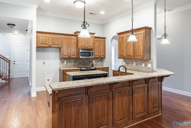 kitchen with hardwood / wood-style floors, pendant lighting, and kitchen peninsula