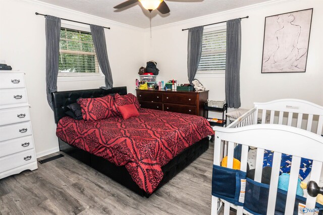 bedroom with ornamental molding, hardwood / wood-style floors, and ceiling fan