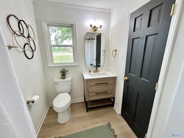 2704 Mctavish Ave SW, Decatur, AL 35603 - bathroom with wood finished floors, toilet, vanity, crown molding, and baseboards