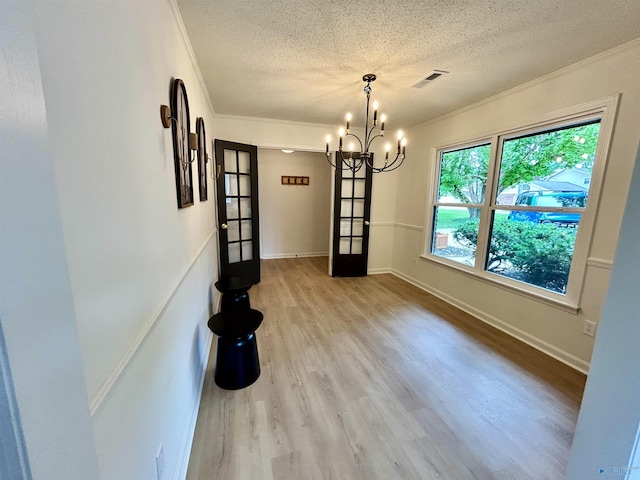 2704 Mctavish Ave SW, Decatur, AL 35603 - unfurnished dining area with a textured ceiling, crown molding, a chandelier, light wood finished floors, and baseboards