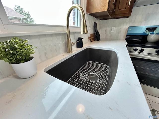 2704 Mctavish Ave SW, Decatur, AL 35603 - kitchen view of a sink, stainless steel electric range oven, dark brown cabinetry, and light countertops