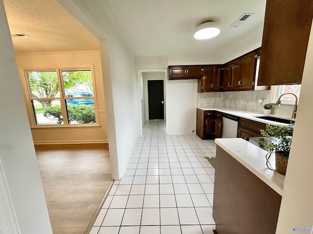 2704 Mctavish Ave SW, Decatur, AL 35603 - kitchen with a sink, dark brown cabinetry, light countertops, dishwasher, and backsplash