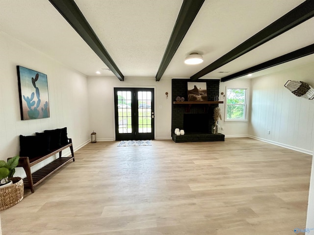 2704 Mctavish Ave SW, Decatur, AL 35603 - living room with beamed ceiling, baseboards, light wood-type flooring, a fireplace, and french doors