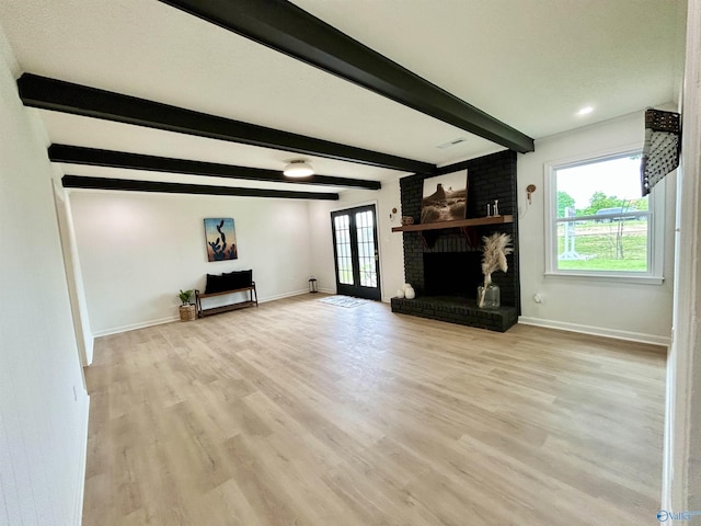 2704 Mctavish Ave SW, Decatur, AL 35603 - unfurnished living room featuring baseboards, beamed ceiling, light wood-type flooring, and a brick fireplace