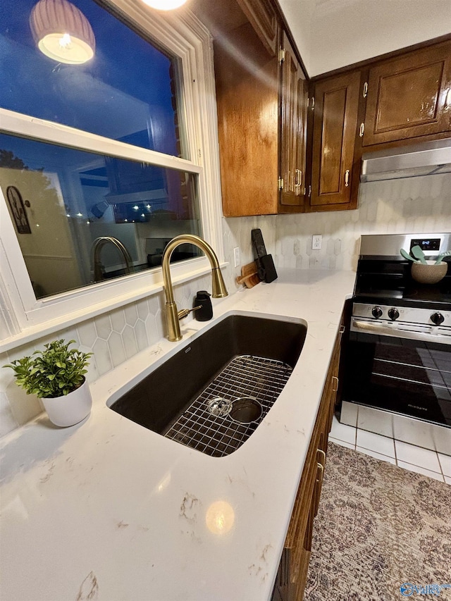 2704 Mctavish Ave SW, Decatur, AL 35603 - kitchen with stainless steel electric range oven, a sink, tasteful backsplash, light countertops, and dark brown cabinets