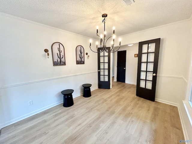 2704 Mctavish Ave SW, Decatur, AL 35603 - unfurnished dining area with french doors, crown molding, a textured ceiling, wood finished floors, and a chandelier