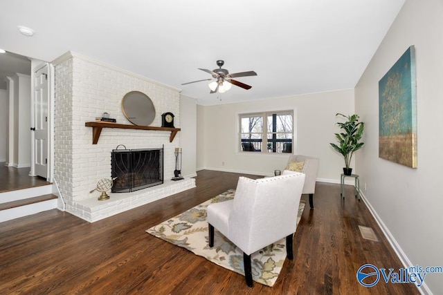 living room with dark wood-type flooring, ceiling fan, and a brick fireplace