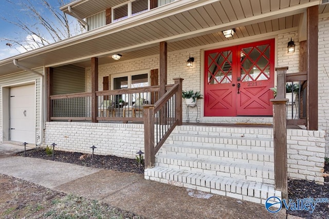 view of exterior entry with a garage and covered porch