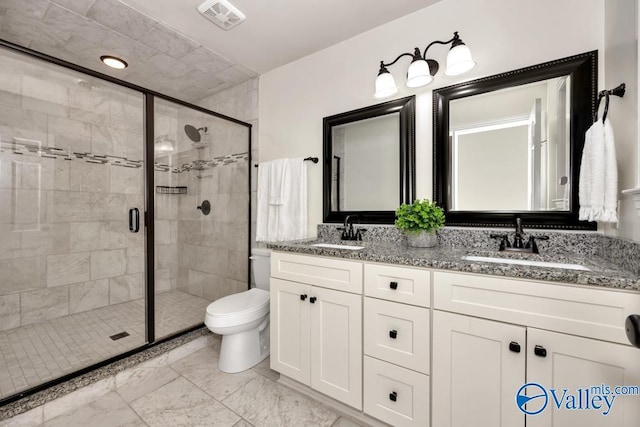 bathroom featuring vanity, a shower with door, and toilet