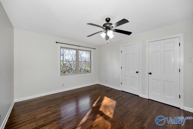 unfurnished bedroom featuring ceiling fan and dark hardwood / wood-style floors