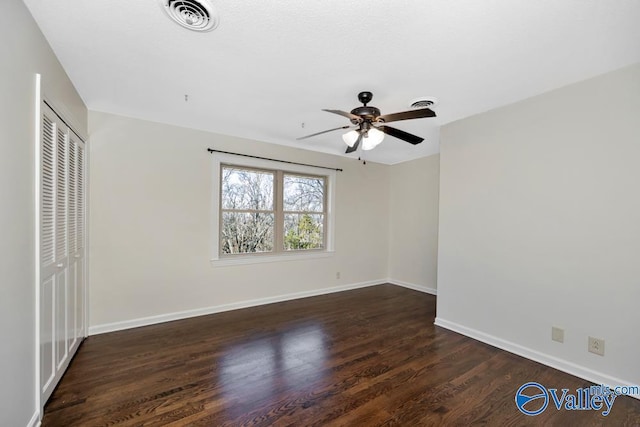 unfurnished bedroom with dark wood-type flooring, a closet, and ceiling fan