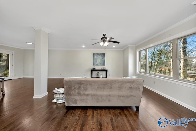 living room with dark wood-type flooring, ornamental molding, and decorative columns