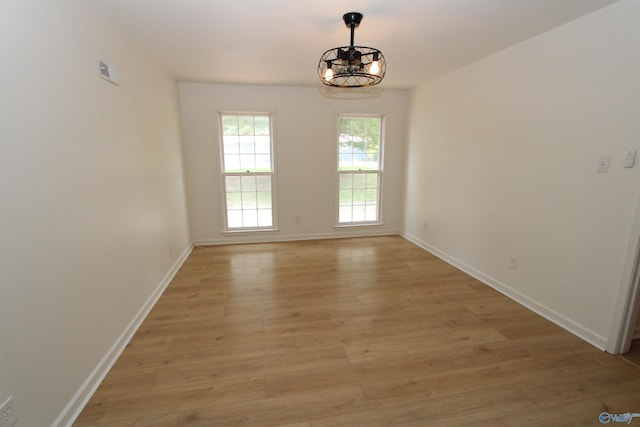 233 Shaw Rd NW, Hartselle, AL 35640 - empty room with light wood finished floors, baseboards, and a chandelier