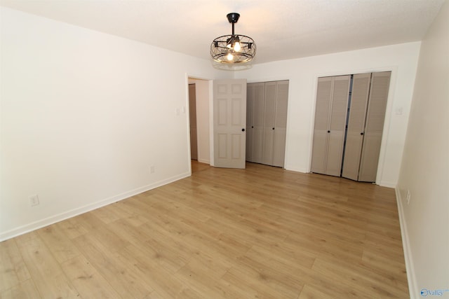233 Shaw Rd NW, Hartselle, AL 35640 - unfurnished bedroom with multiple closets, baseboards, and light wood finished floors