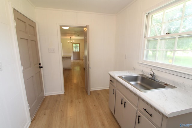233 Shaw Rd NW, Hartselle, AL 35640 - kitchen with light wood-style floors, a sink, a chandelier, white cabinets, and crown molding