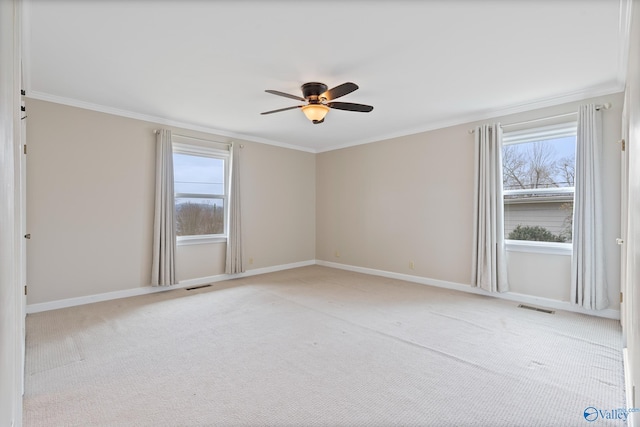 carpeted empty room featuring crown molding, a wealth of natural light, and ceiling fan