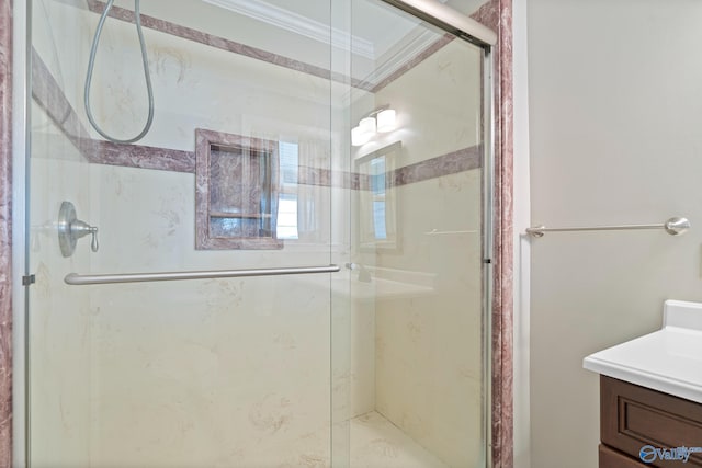 bathroom with crown molding, vanity, and a shower with shower door