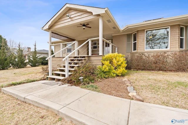 view of front facade with ceiling fan and a front lawn