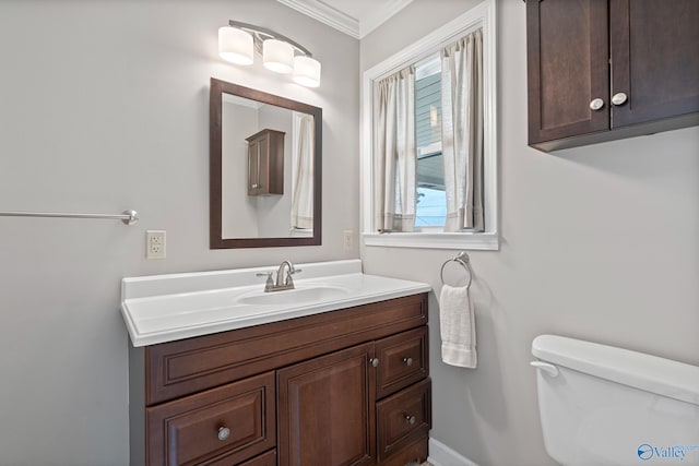 bathroom featuring vanity, crown molding, and toilet