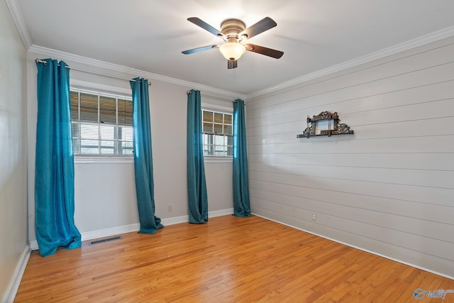 unfurnished room with ornamental molding, ceiling fan, and light wood-type flooring