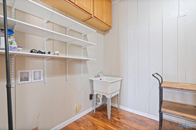 laundry area featuring cabinets, hardwood / wood-style flooring, and washer hookup