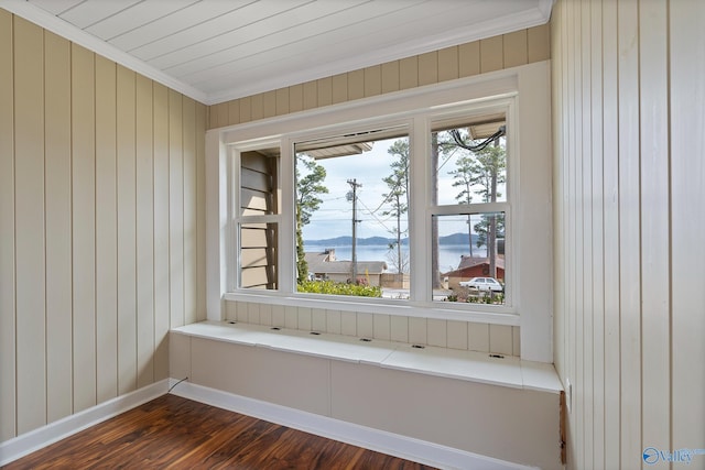 room details featuring hardwood / wood-style flooring, wooden walls, ornamental molding, and a water view