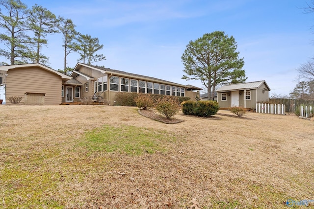 back of property with a sunroom and a lawn