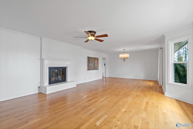 unfurnished living room featuring ornamental molding, ceiling fan with notable chandelier, and light hardwood / wood-style floors