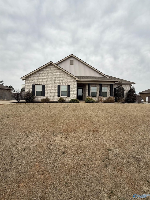 view of front of property featuring a front yard and brick siding