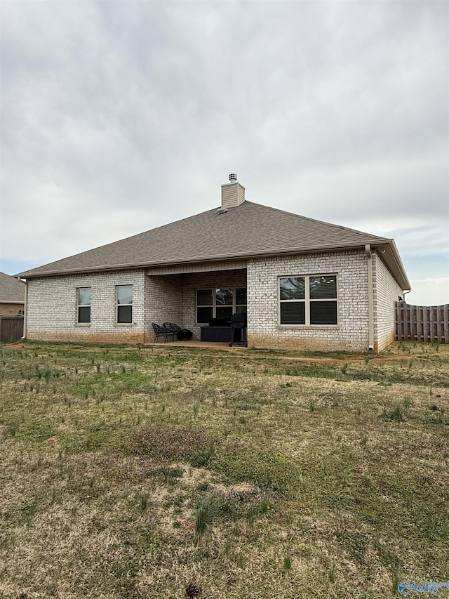 115 Richard Rd NE, Huntsville, AL 35811 - back of property featuring brick siding, fence, a chimney, and roof with shingles