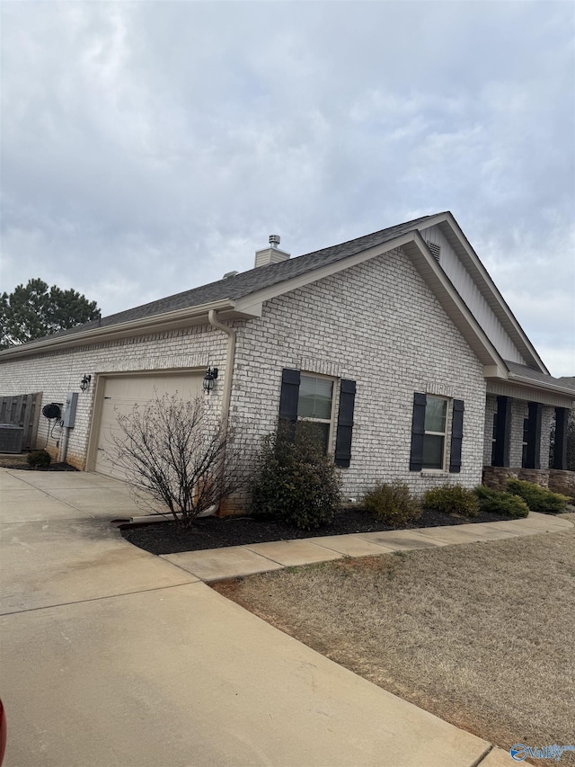 115 Richard Rd NE, Huntsville, AL 35811 - view of side of home with driveway, a chimney, a garage, and brick siding