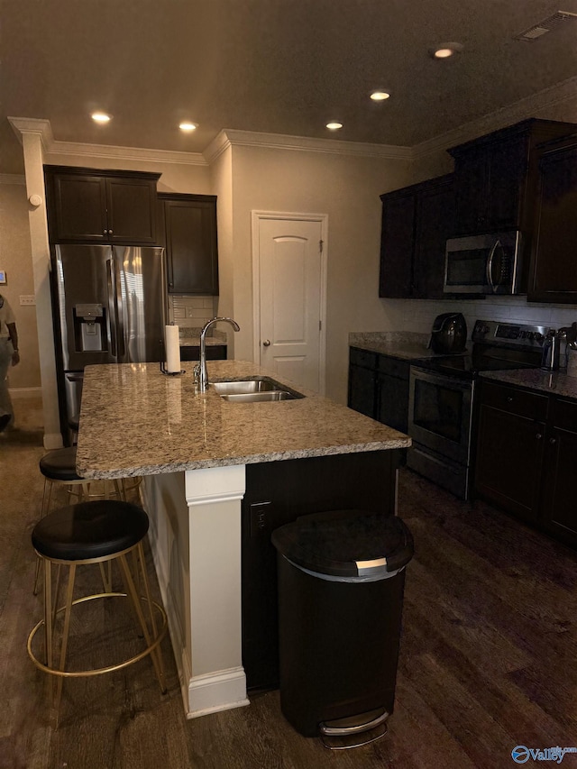 115 Richard Rd NE, Huntsville, AL 35811 - kitchen featuring a breakfast bar area, dark wood finished floors, a sink, a kitchen island with sink, and appliances with stainless steel finishes
