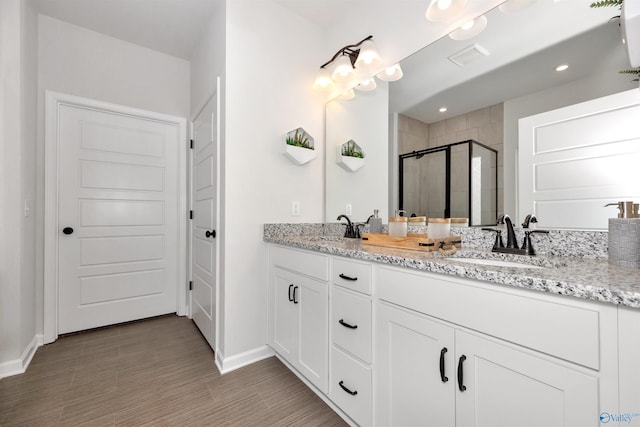 bathroom with vanity, an enclosed shower, and hardwood / wood-style floors