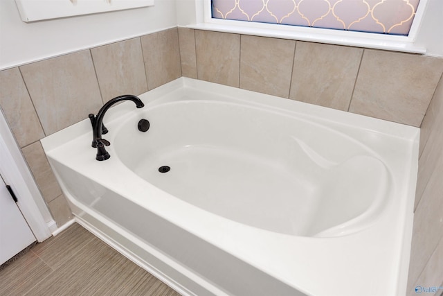 bathroom featuring tile patterned floors and a bath