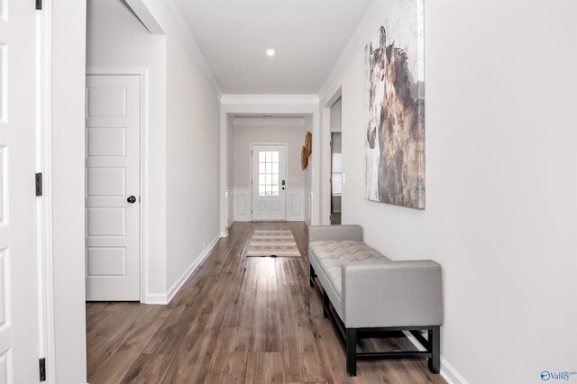 corridor with hardwood / wood-style floors and crown molding