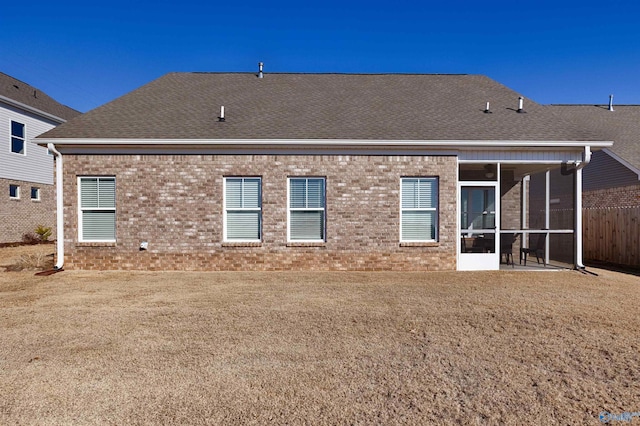 back of house featuring a sunroom and a lawn