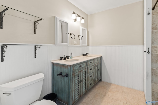412 Oshaughnessy Ave NE, Huntsville, AL 35801 - bathroom with toilet, wainscoting, double vanity, and tile patterned floors