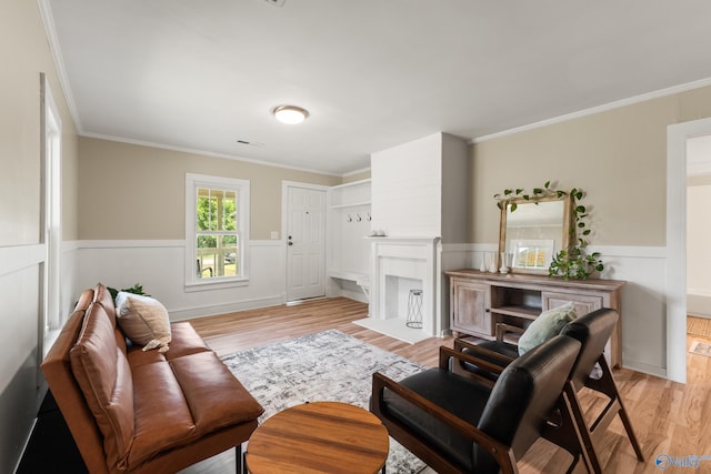 412 Oshaughnessy Ave NE, Huntsville, AL 35801 - living room with crown molding, light wood-style flooring, a wainscoted wall, and a fireplace with flush hearth