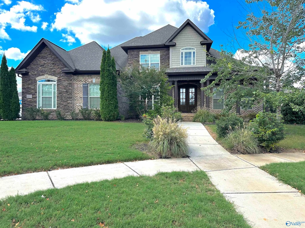 craftsman house with a front yard and french doors