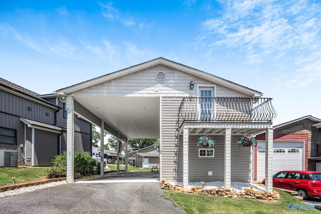 view of front of property with a carport, a balcony, and cooling unit