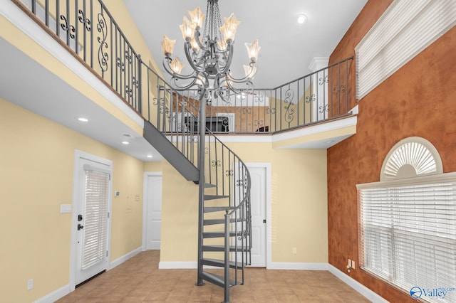 stairway with a high ceiling, tile patterned flooring, and an inviting chandelier