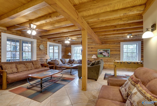 living room featuring beamed ceiling, rustic walls, light tile patterned floors, ceiling fan, and wooden ceiling